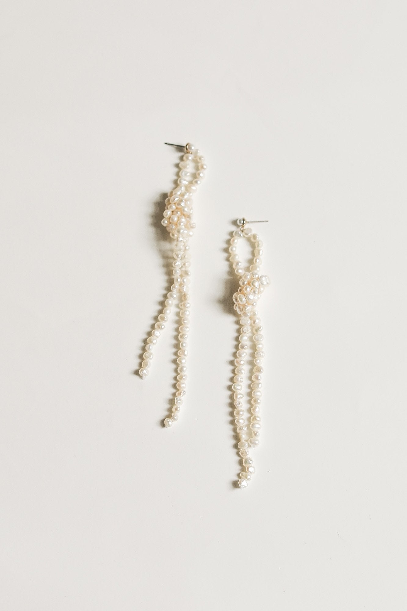 Flat photo of the knotted freshwater pearl earrings by AB Ellie on a white background