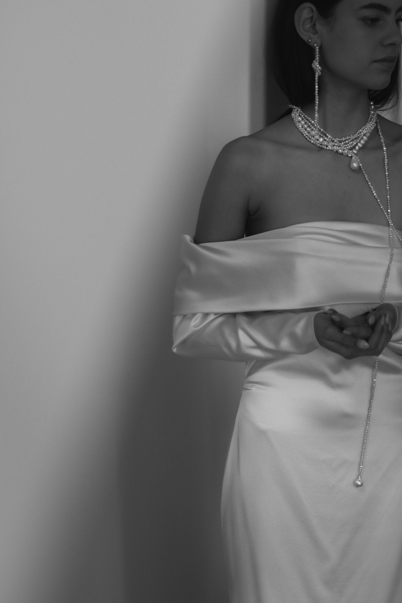 Black and white photo of brunette bride wearing the knotted freshwater pearl earrings by AB Ellie with a strapless dress