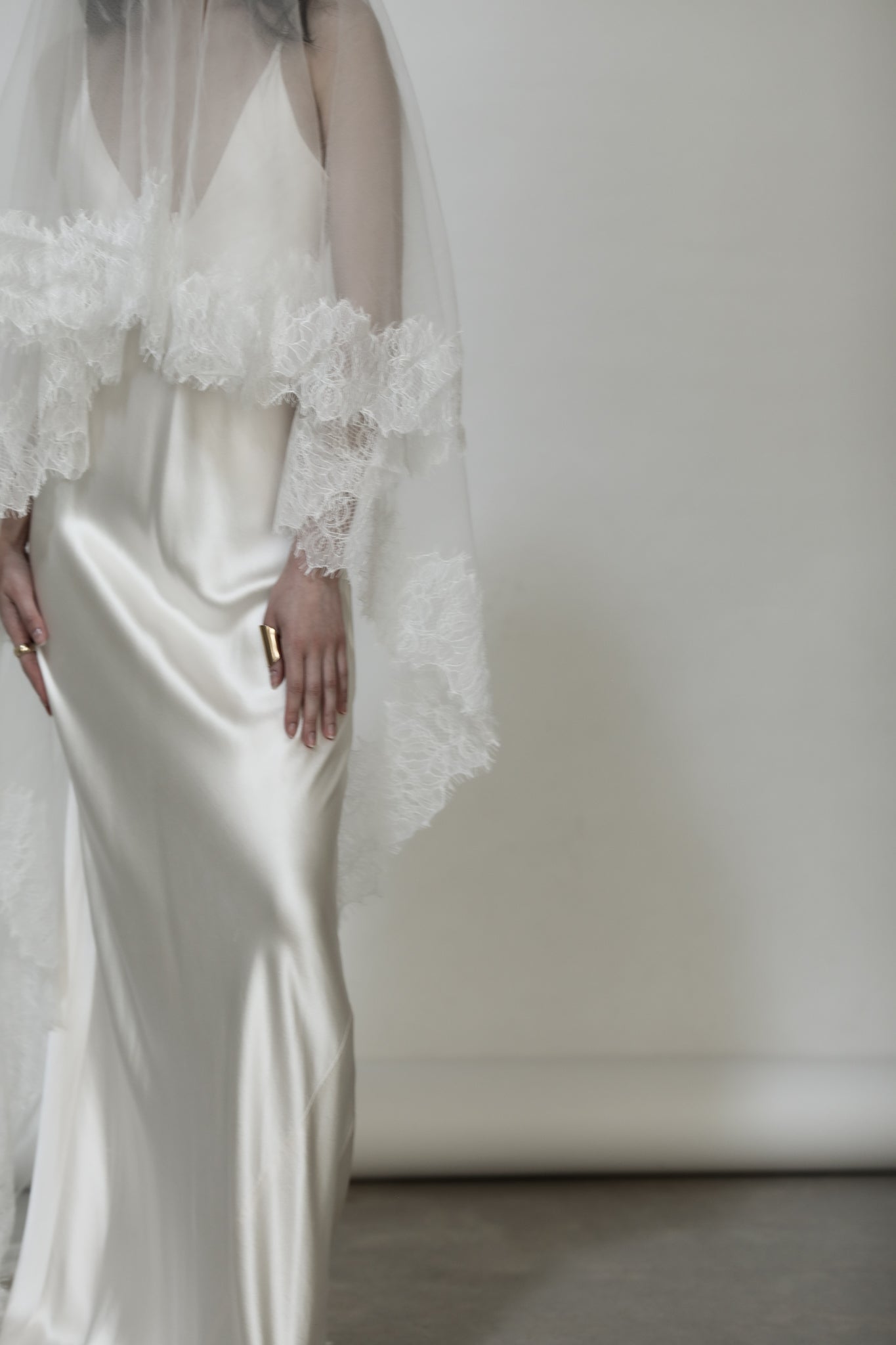 Bride in silk wedding dress with lace mantilla bridal veil and blusher