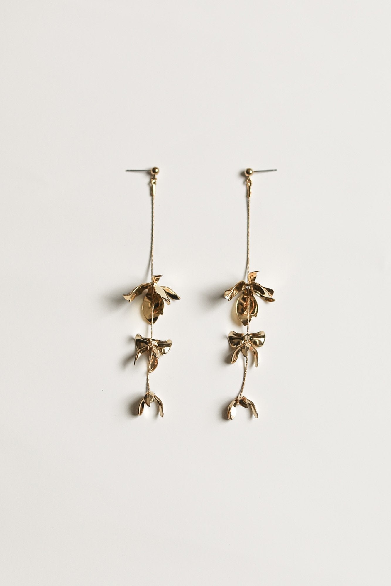 Flat photo of the gold Magnolia Strand earrings by A.B. Ellie on white background