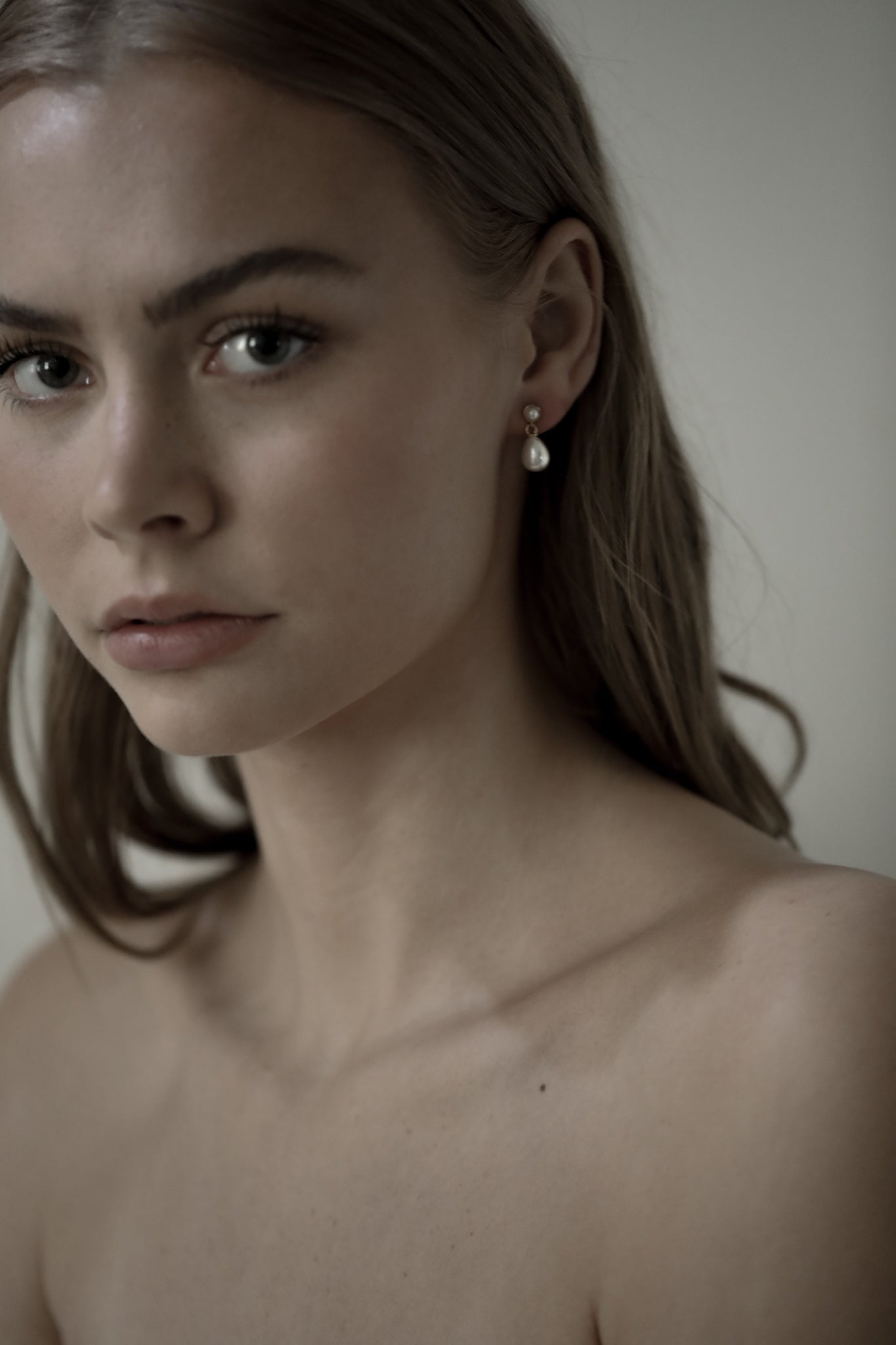 Front photo of sandy blonde bride wearing the micro pearl drop earrings by AB Ellie Studio Bride Collection with strapless dress