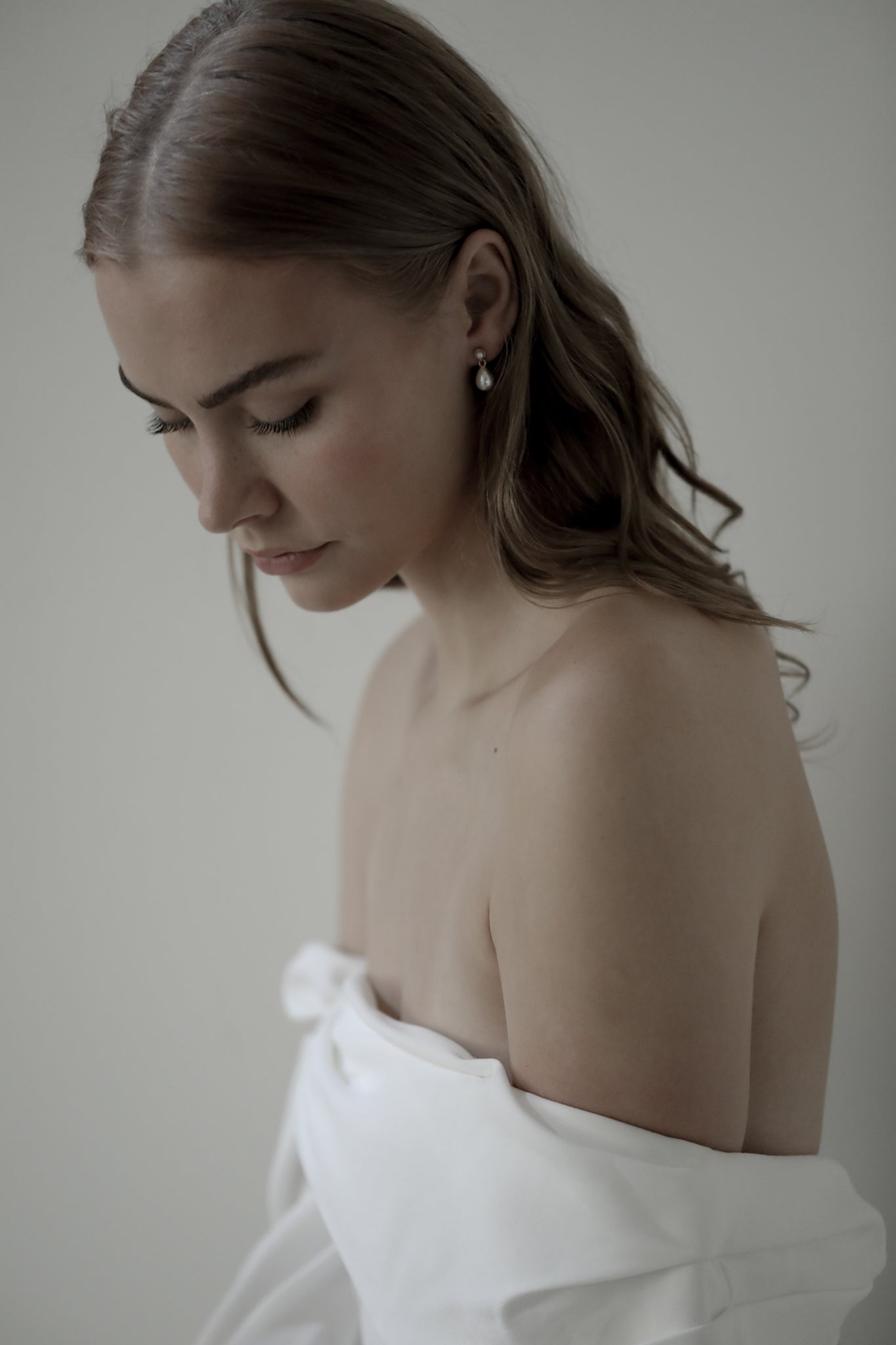 Photo of sandy blonde bride proline wearing the micro pearl drop earrings by AB Ellie Studio Bride collection