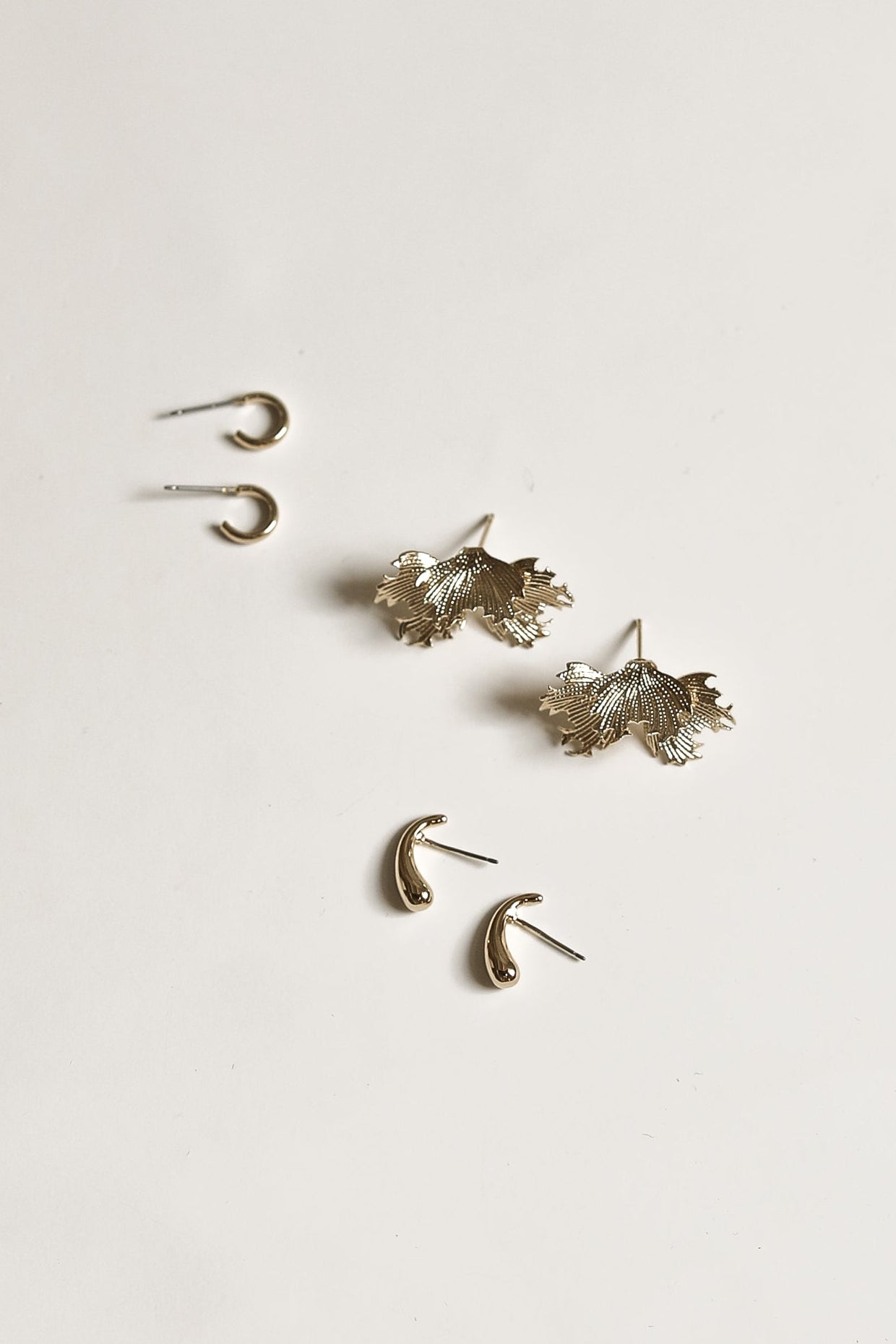Set of gold earrings on a white background