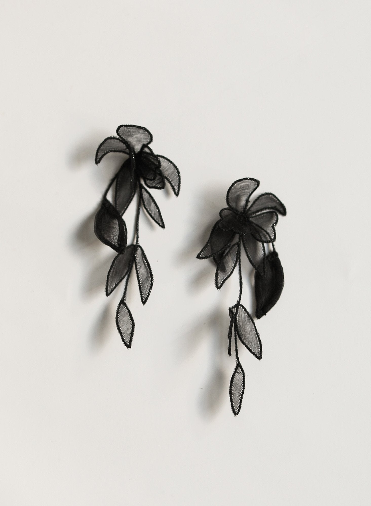 Flat photo of the black mini charlee tier earrings by AB Ellie on white background