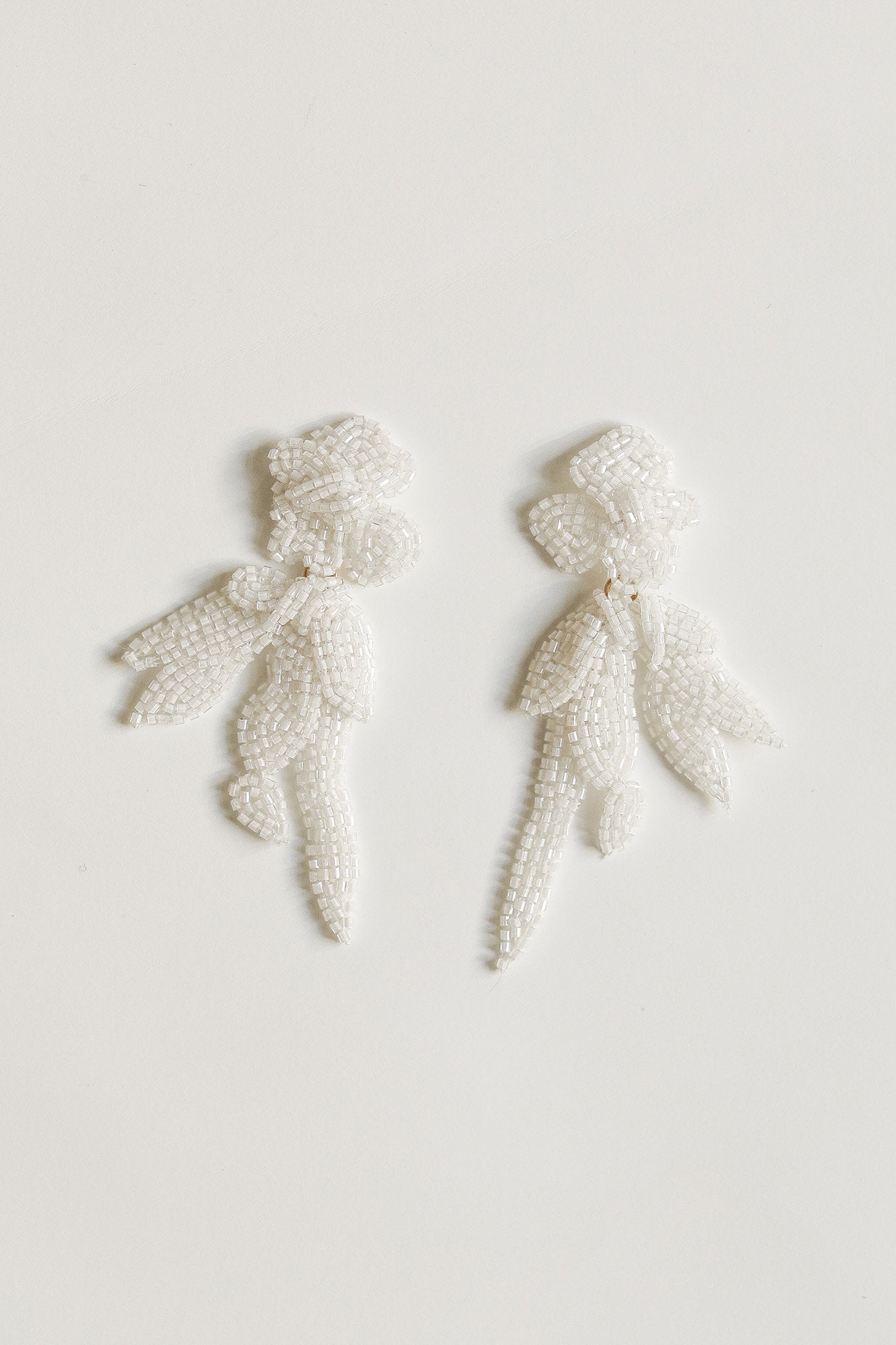 Flat photo of the ivory mini maj drop earrings by AB Eliie on a white background