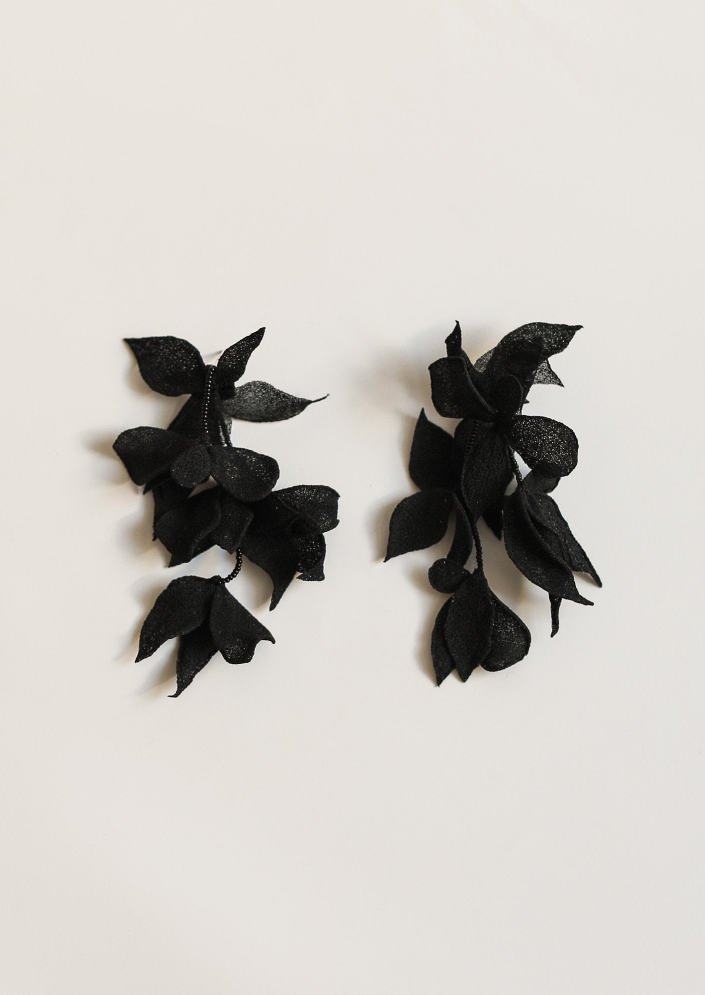 Flat image of the mini Nora tier earrings in black by A.B. Ellie on a white background