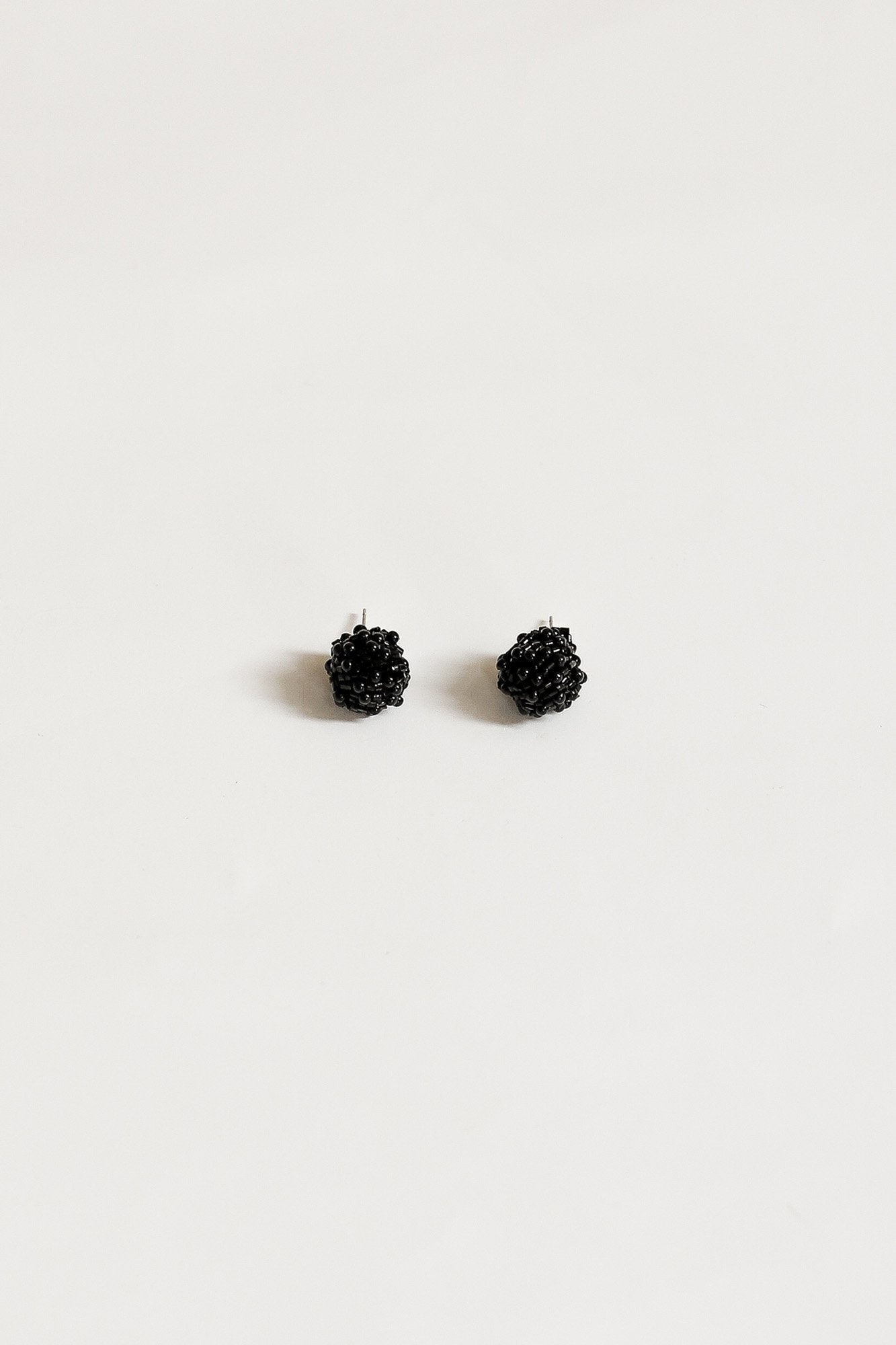 Flat image of the Black Celine Stud with knotted synthetic beading in a stud earring