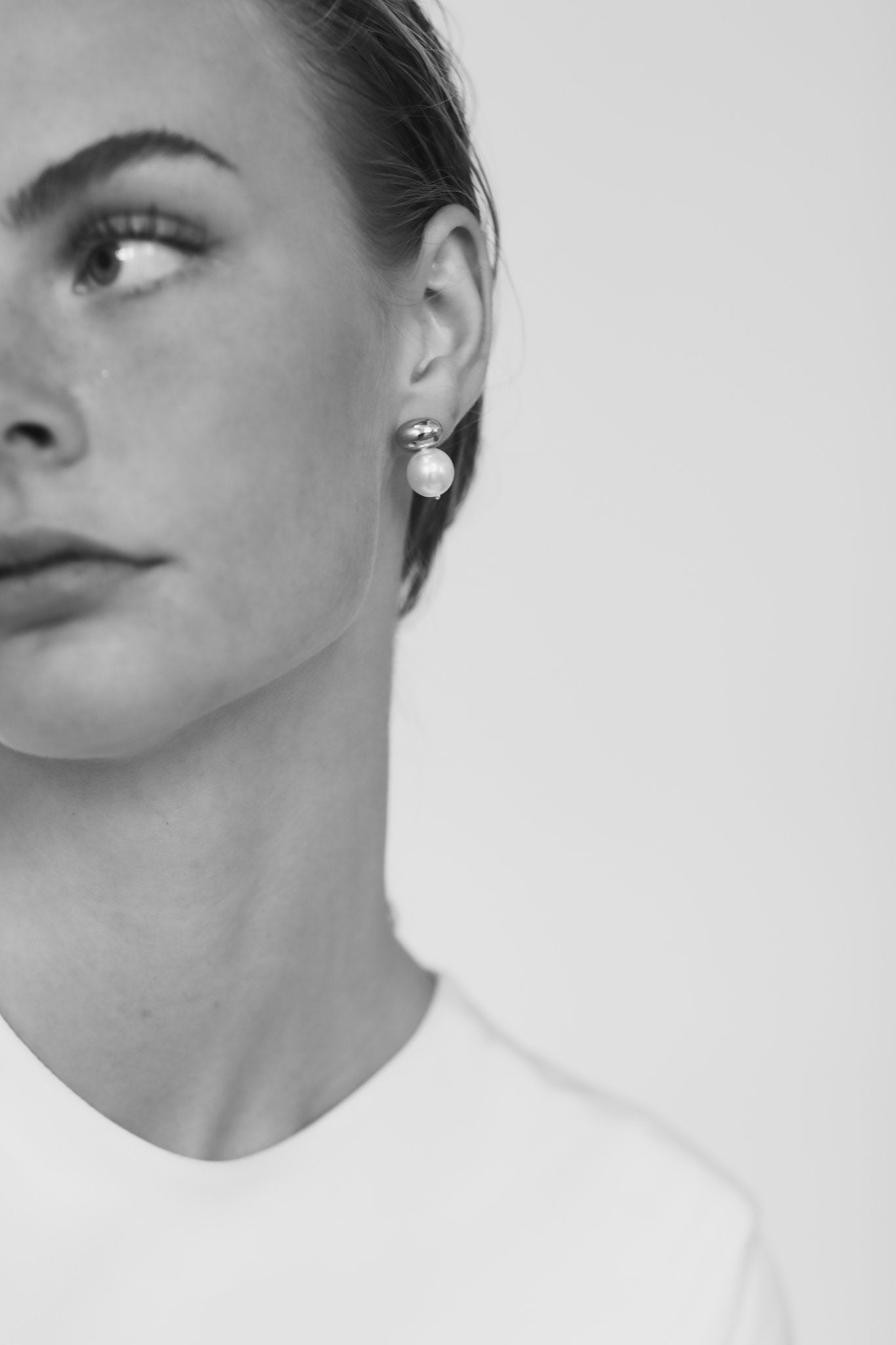Black and white image of front profile view of bride wearing the Orb and Pearl Sphere stud earrings by AB Ellie