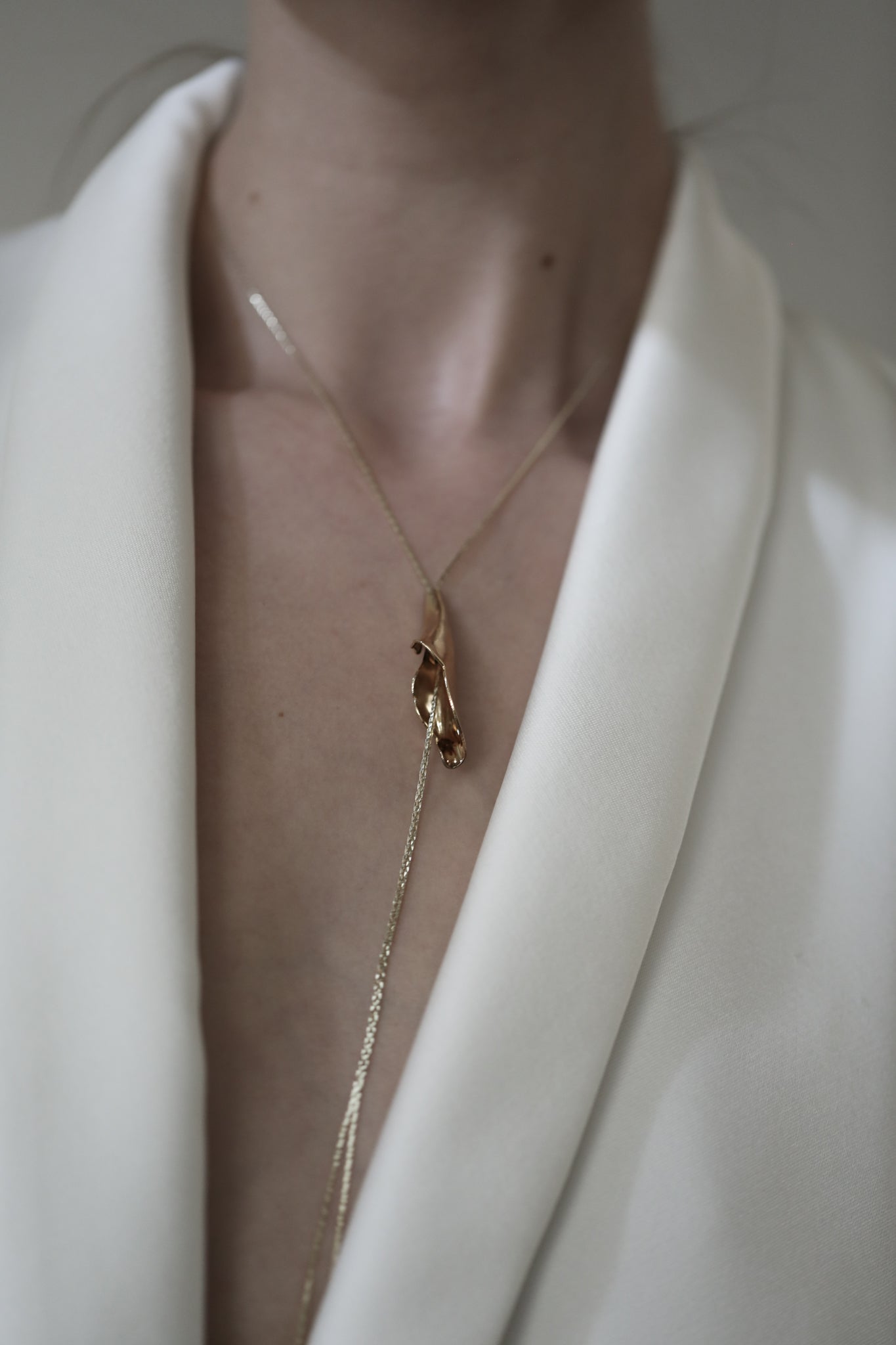 Front photo of bride wearing the sculptural floral Tula gold lariat necklace by AB Ellie