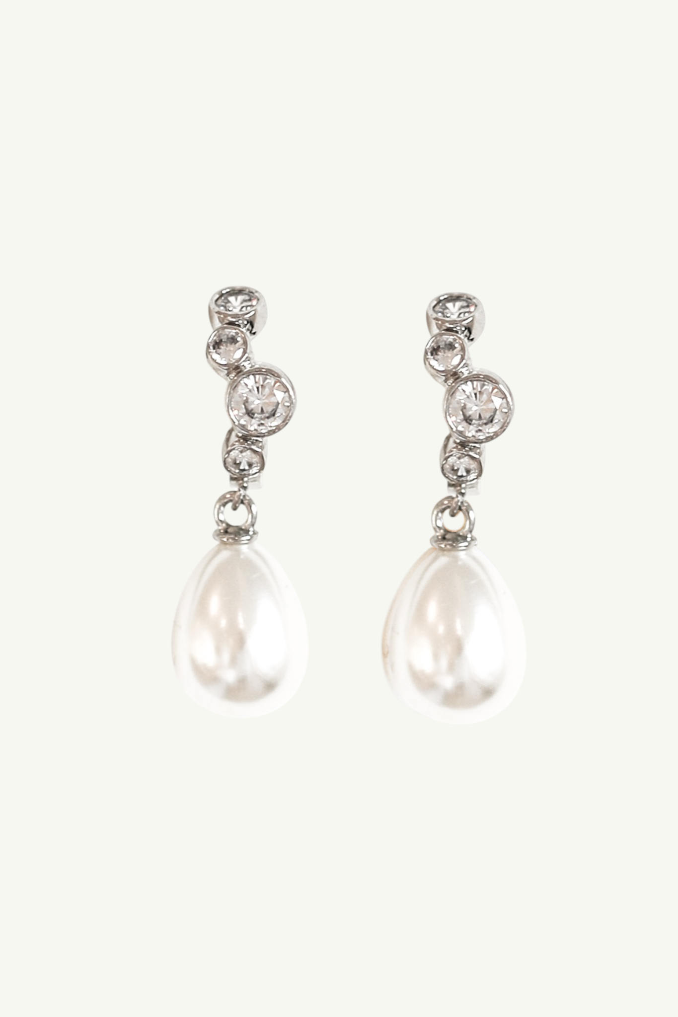 Flat photo of the silver stacked bezel pearl drop hoop earrings by AB Ellie on white background