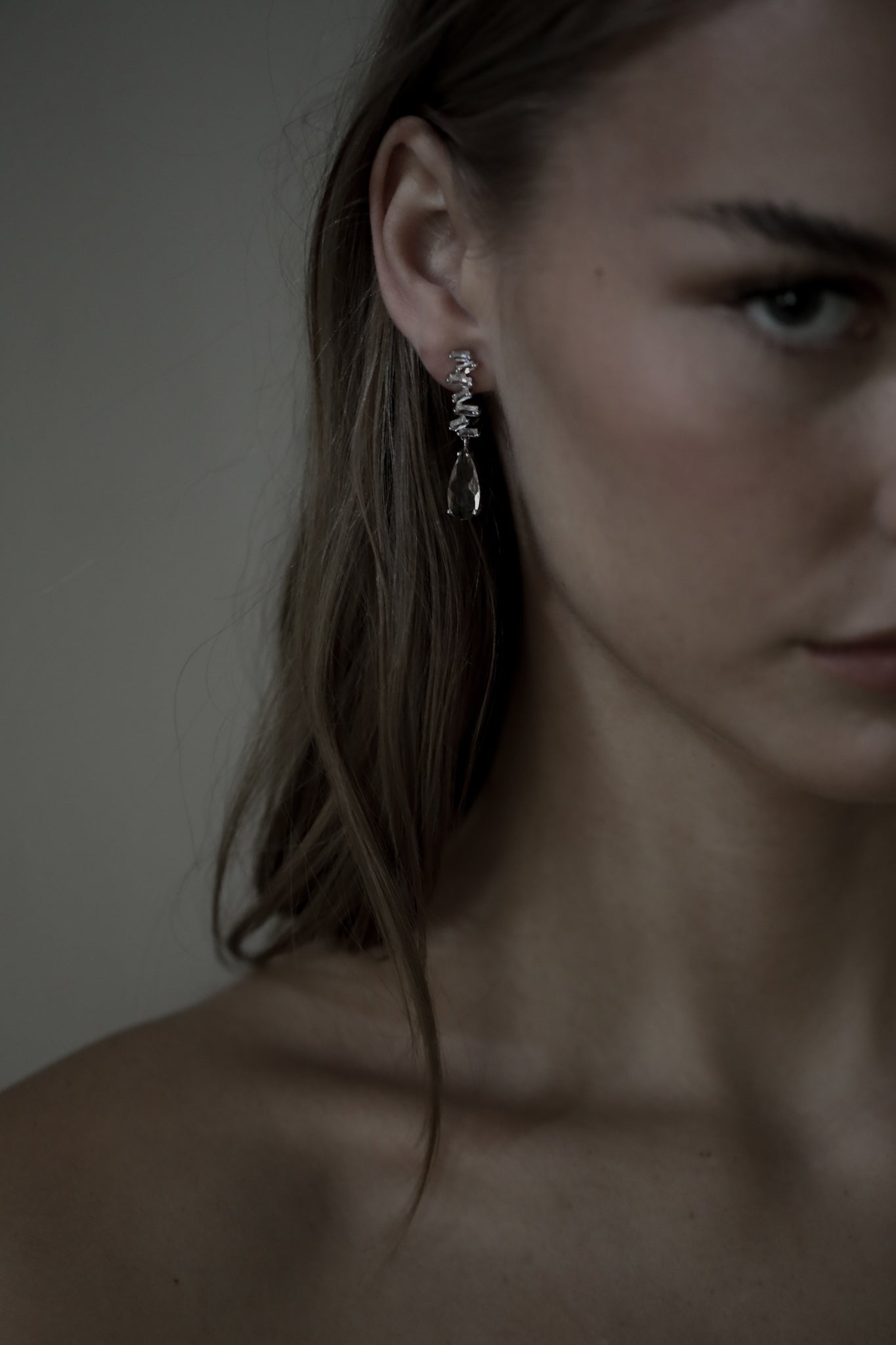 Brunette bride wearing stacked crystal baguette earring featuring a larger crystal drop at the bottom