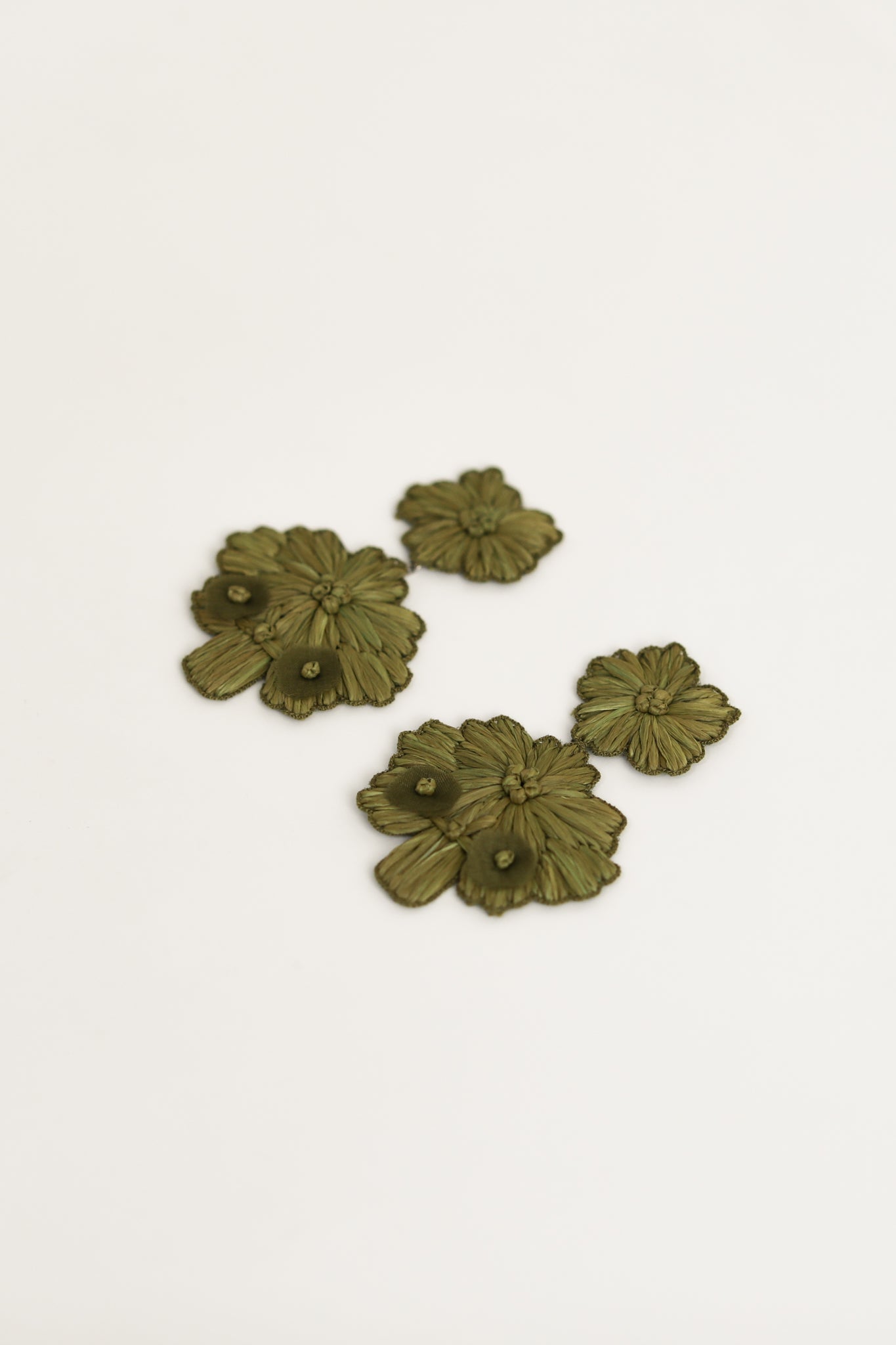 Flat angled image of the Stevie Floral statement earrings in olive color by AB Ellie on white background